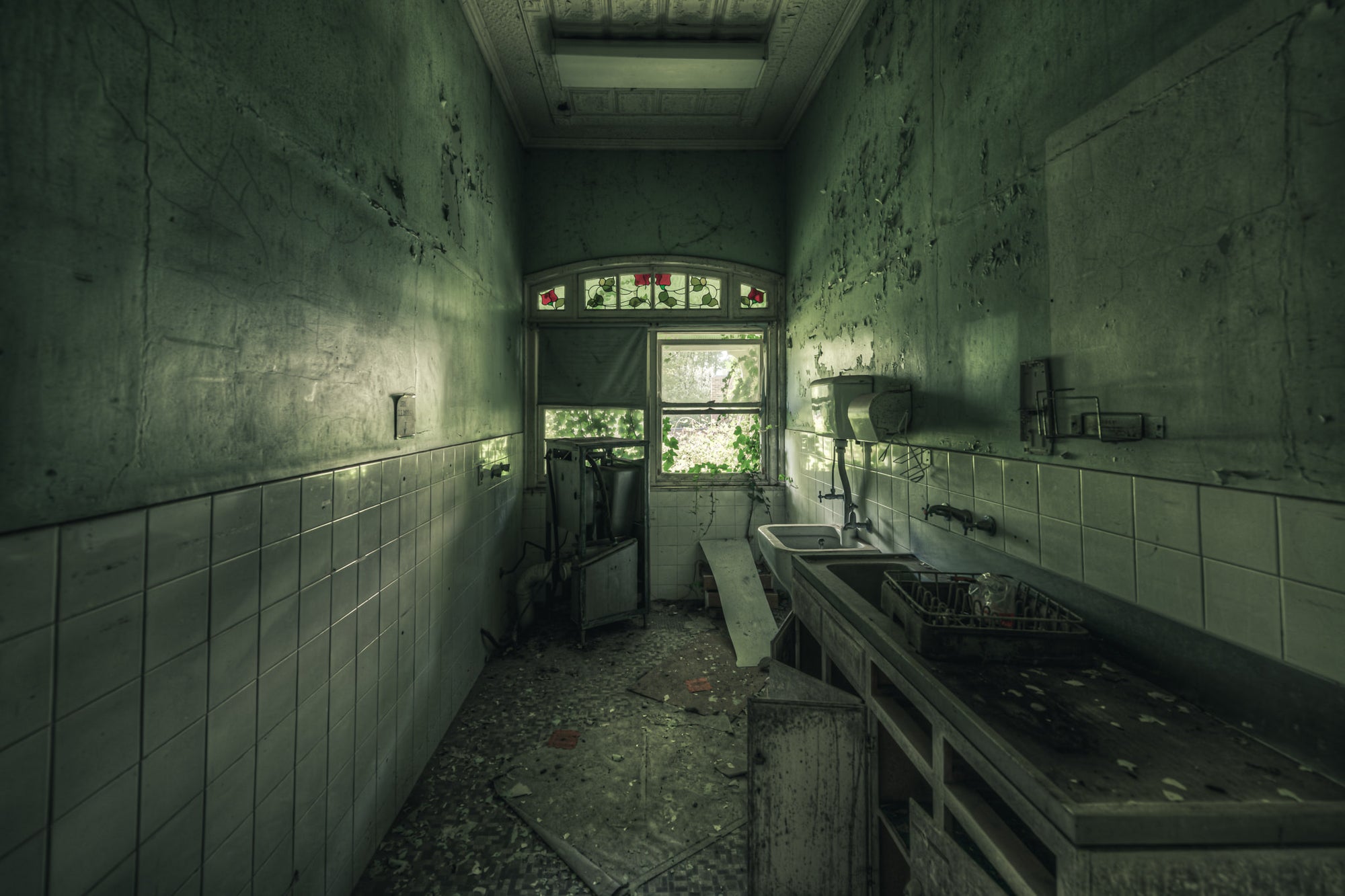 Sluice Room at The Asylum, a narrow sluice room lined with white ceramic tiles to waist height.