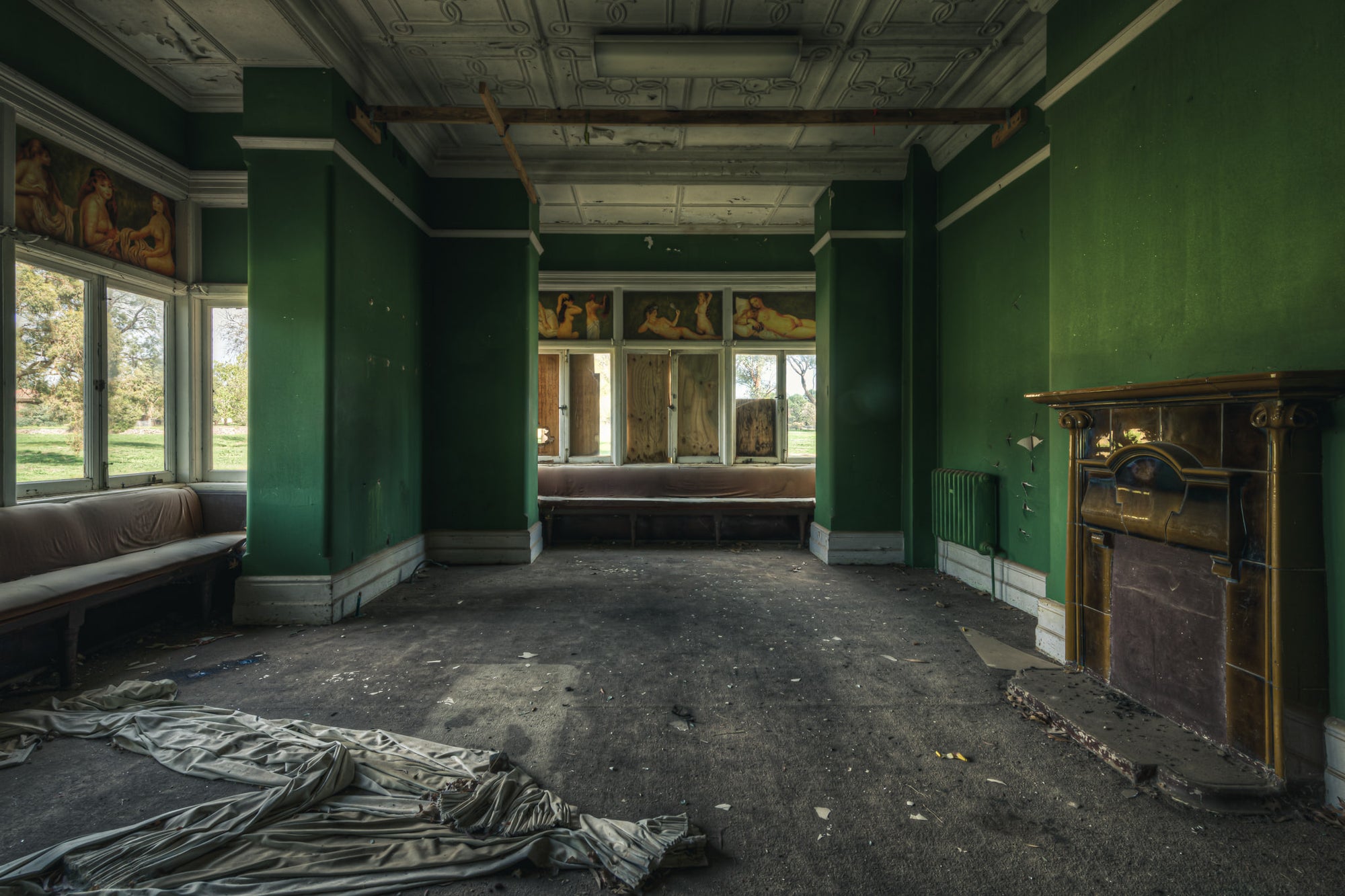 The Green Room at The Asylum, a deserted room with raunchy hand-painted works above the windows.