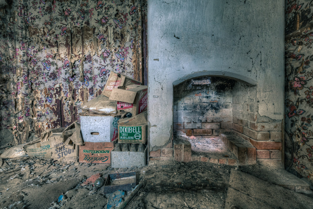 Bedroom Chimney at The Post Office, floral wallpaper peels from both walls in long vertical strips, exposing bare plaster.