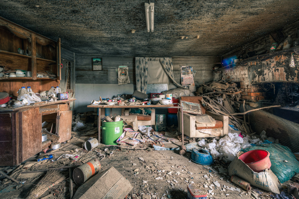 Dining Area at The Post Office, a low timber ceiling, blackened with mould, presses down over a single room.
