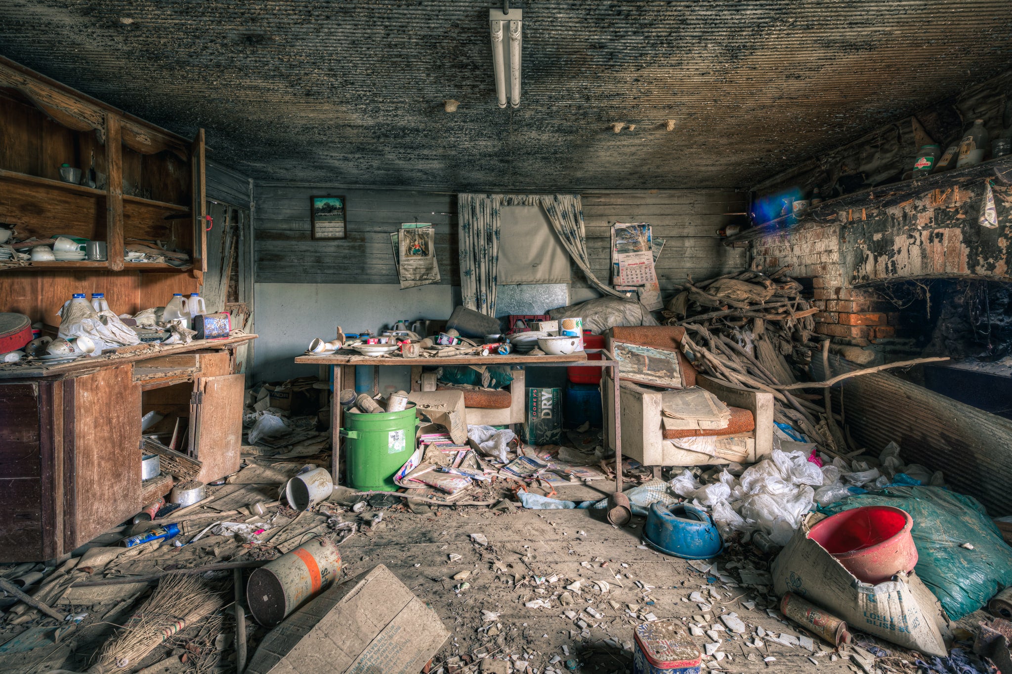Dining Area at The Post Office, a low timber ceiling, blackened with mould, presses down over a single room.