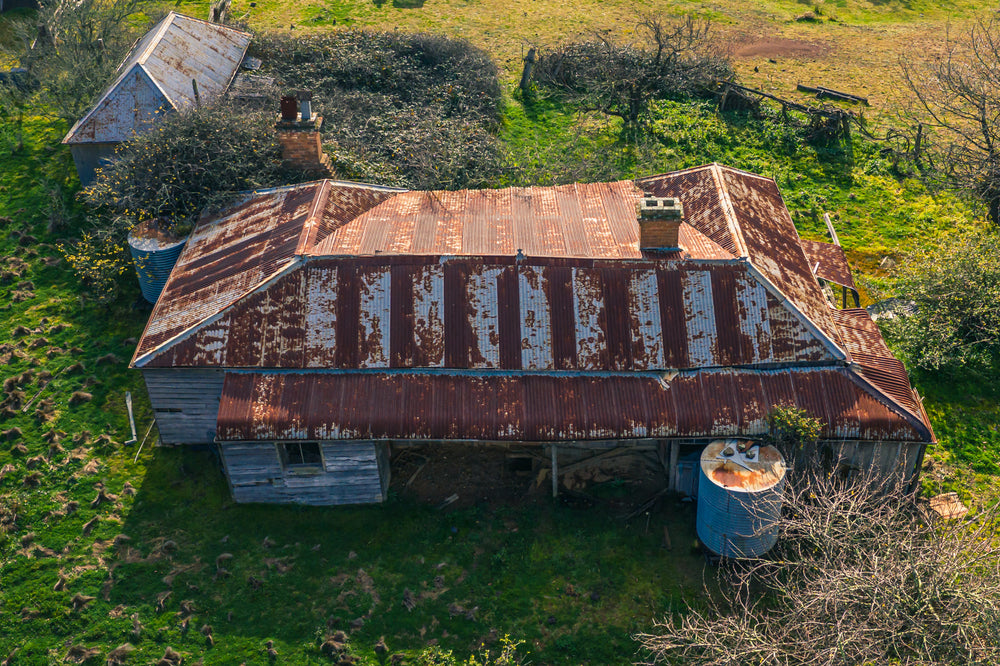 Front Elevated at The Post Office, from above, the building's hipped roof spreads wide across green pasture.