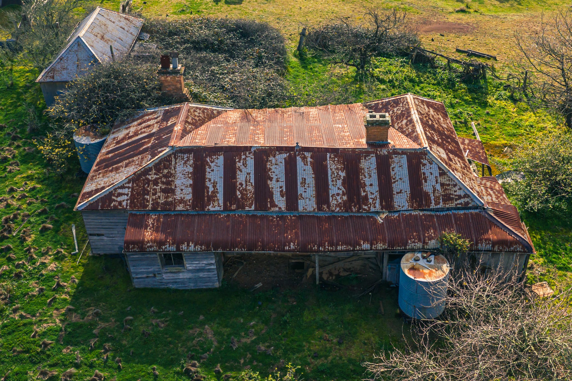 Front Elevated at The Post Office, from above, the building's hipped roof spreads wide across green pasture.