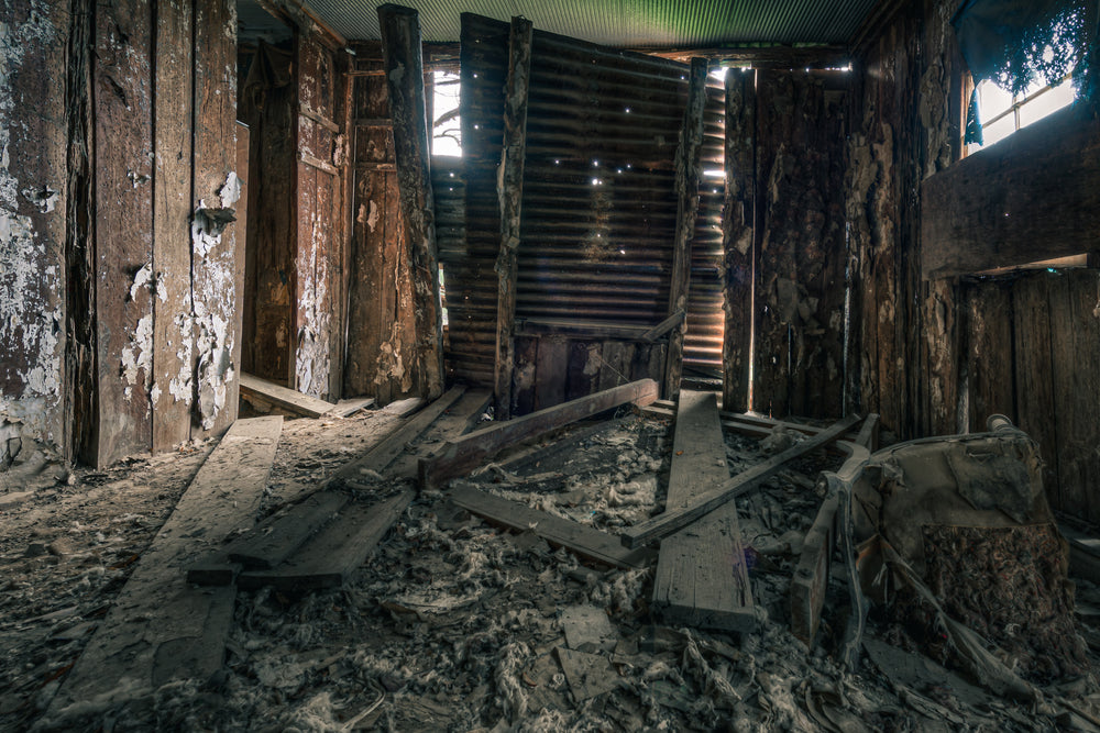 Main Bedroom Floor at The Post Office, pinpoints of daylight pierce the corrugated iron walls.