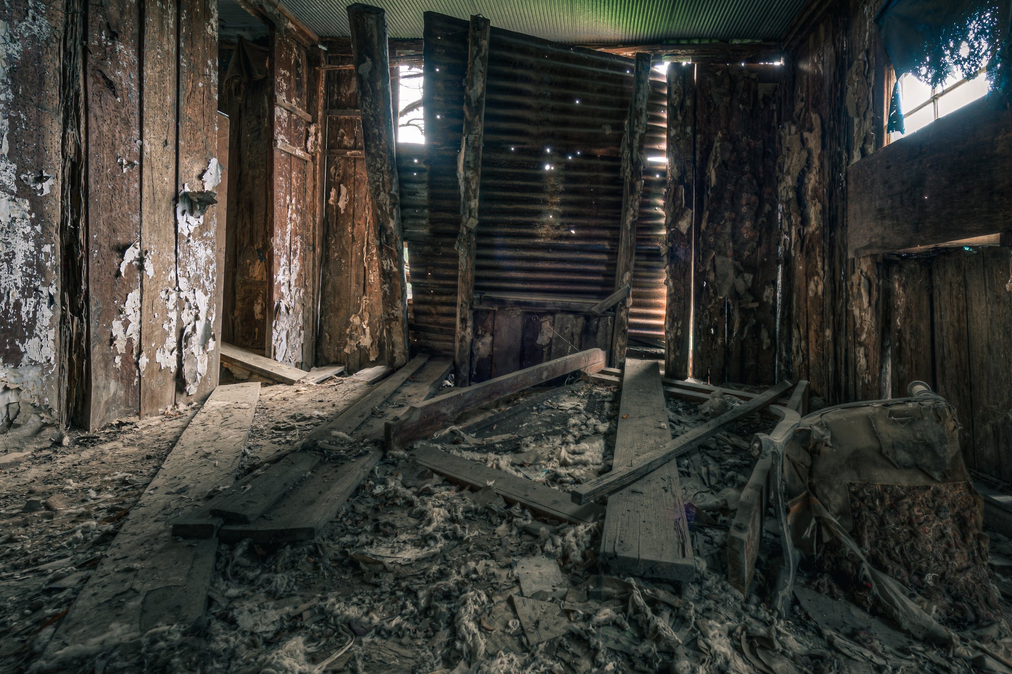 Main Bedroom Floor at The Post Office, pinpoints of daylight pierce the corrugated iron walls.