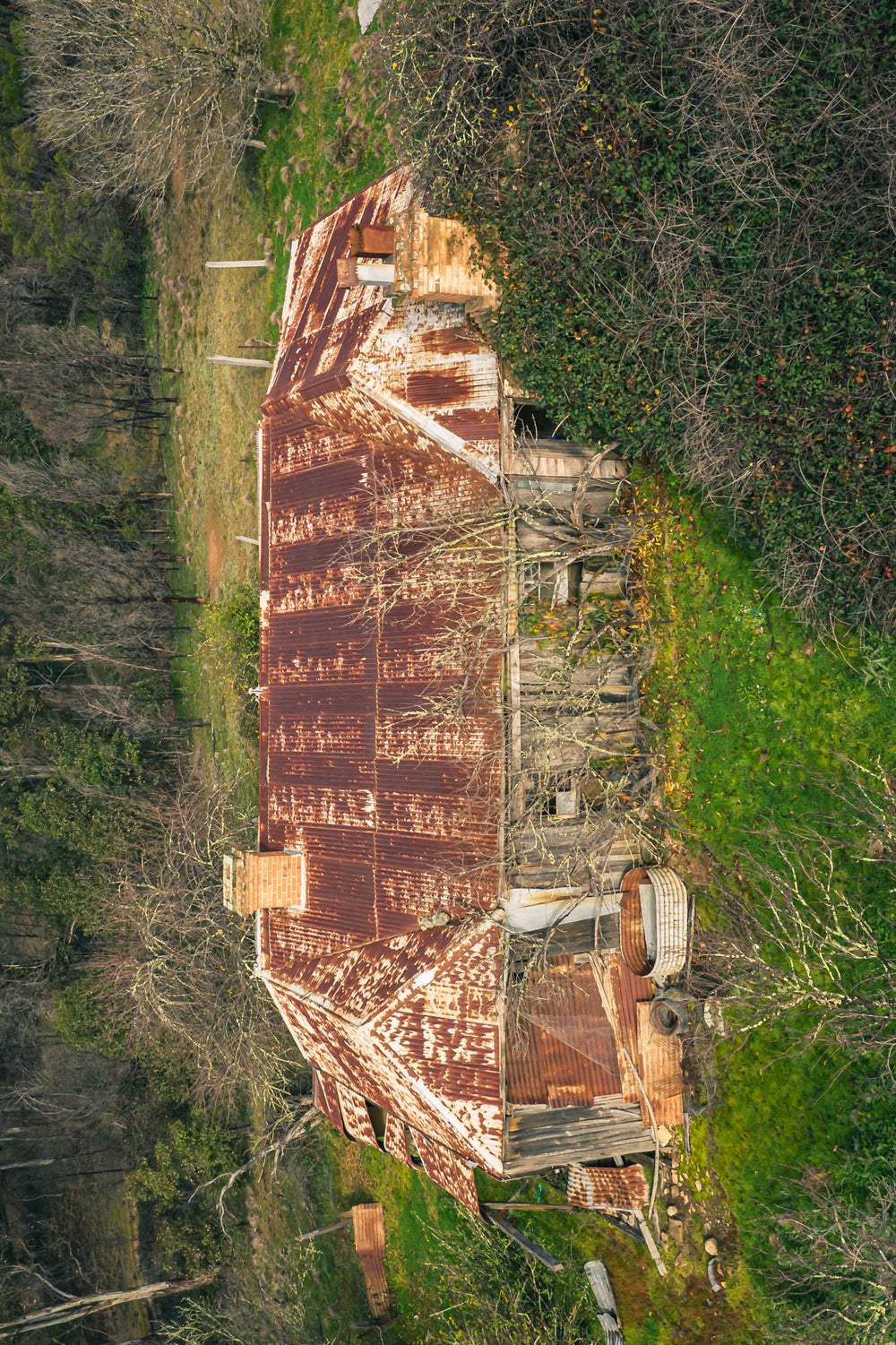 Rear Residence Topdown at The Post Office, corrugated iron roof stretches across the full frame, rust bleeding.