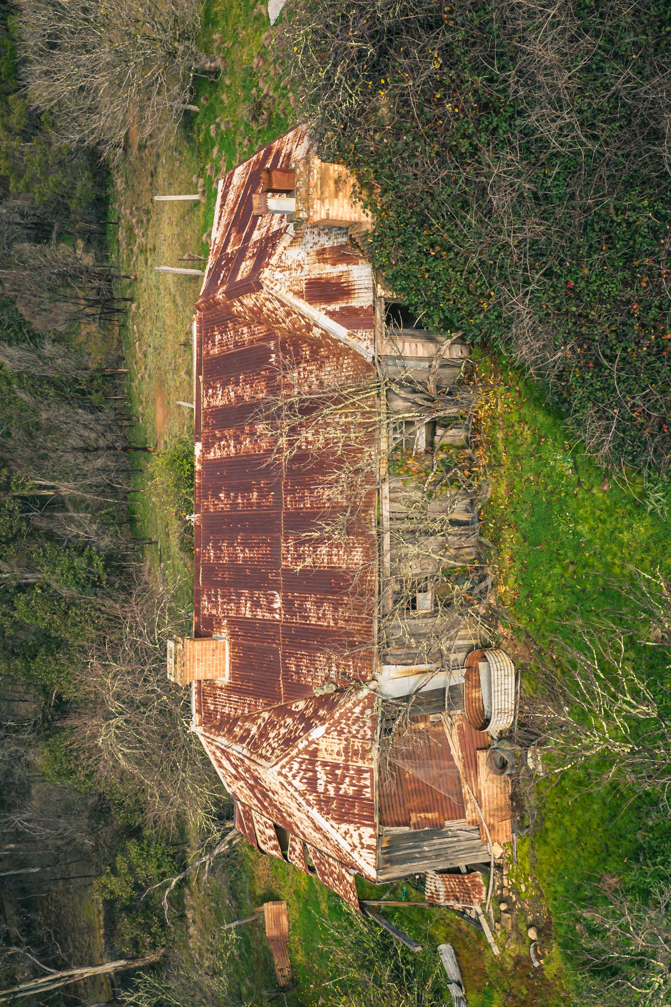 Rear Residence Topdown at The Post Office, corrugated iron roof stretches across the full frame, rust bleeding.