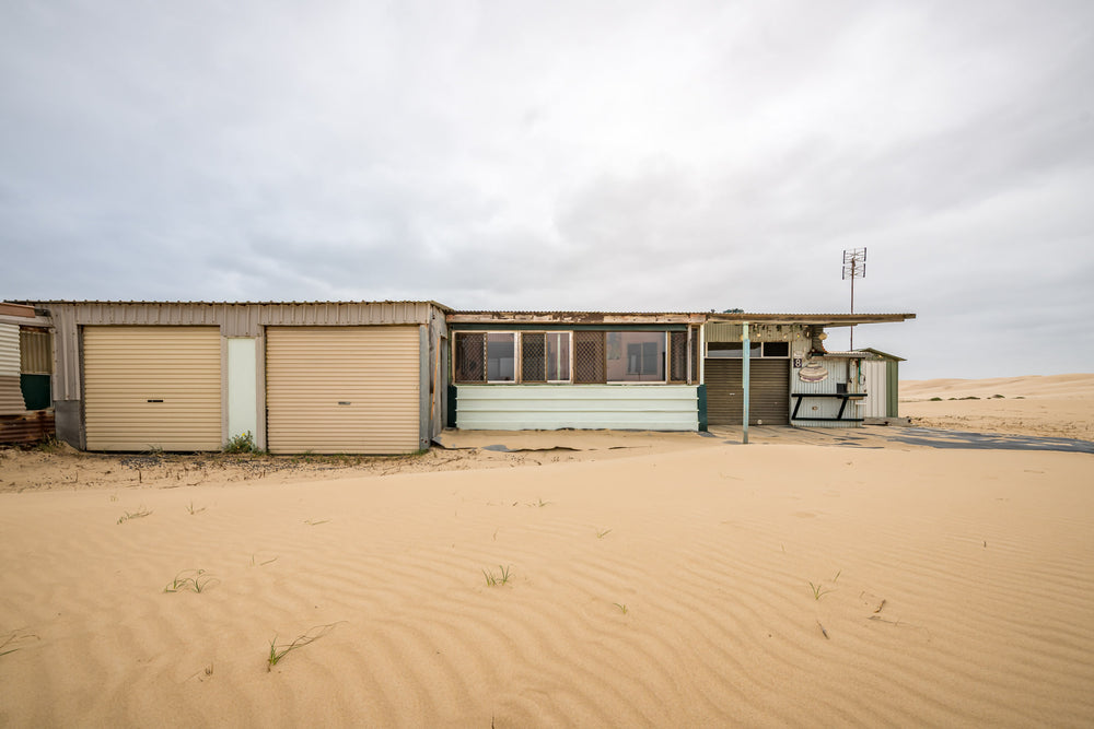 Eight at Tin City, sand drifts in low ripples across what used to be ground level.