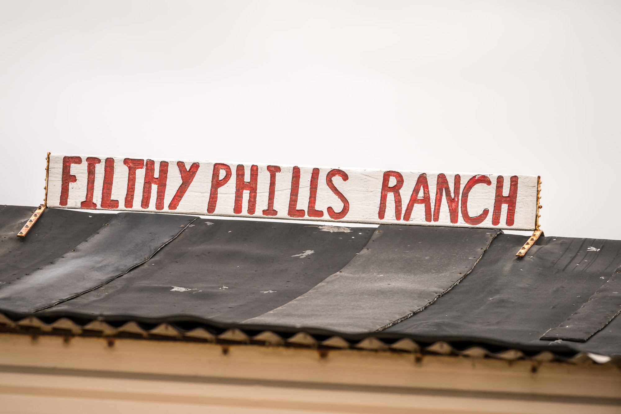 Signage at Tin City, a hand-painted sign sits bolted to the roofline.