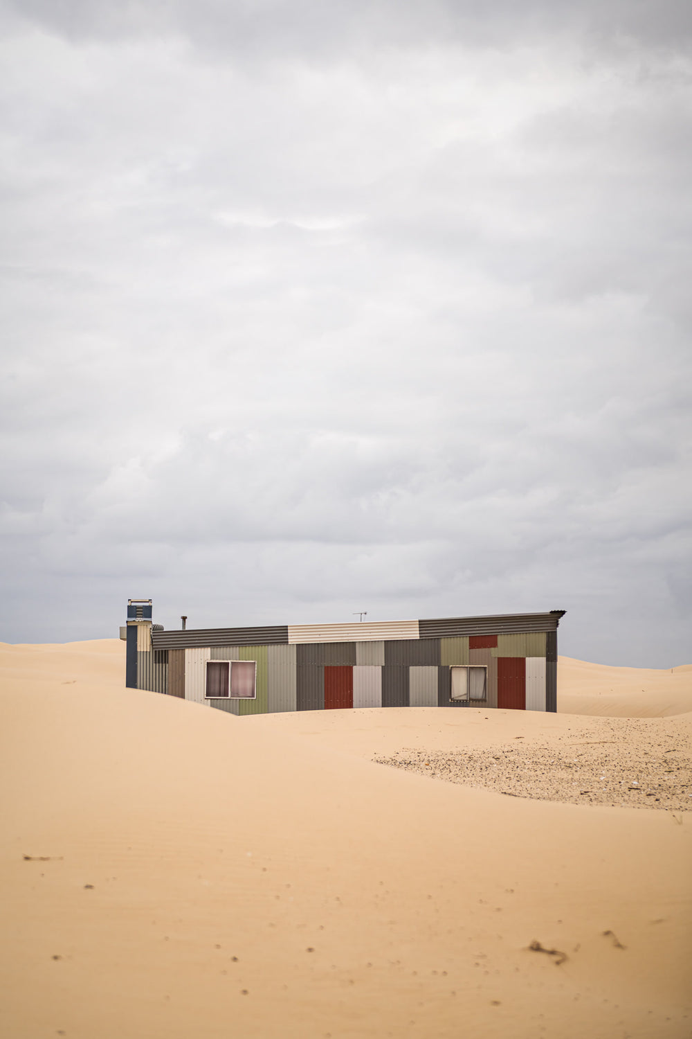 Waves at Tin City, a corrugated iron shack sits half-swallowed by sand dunes at Tin City.