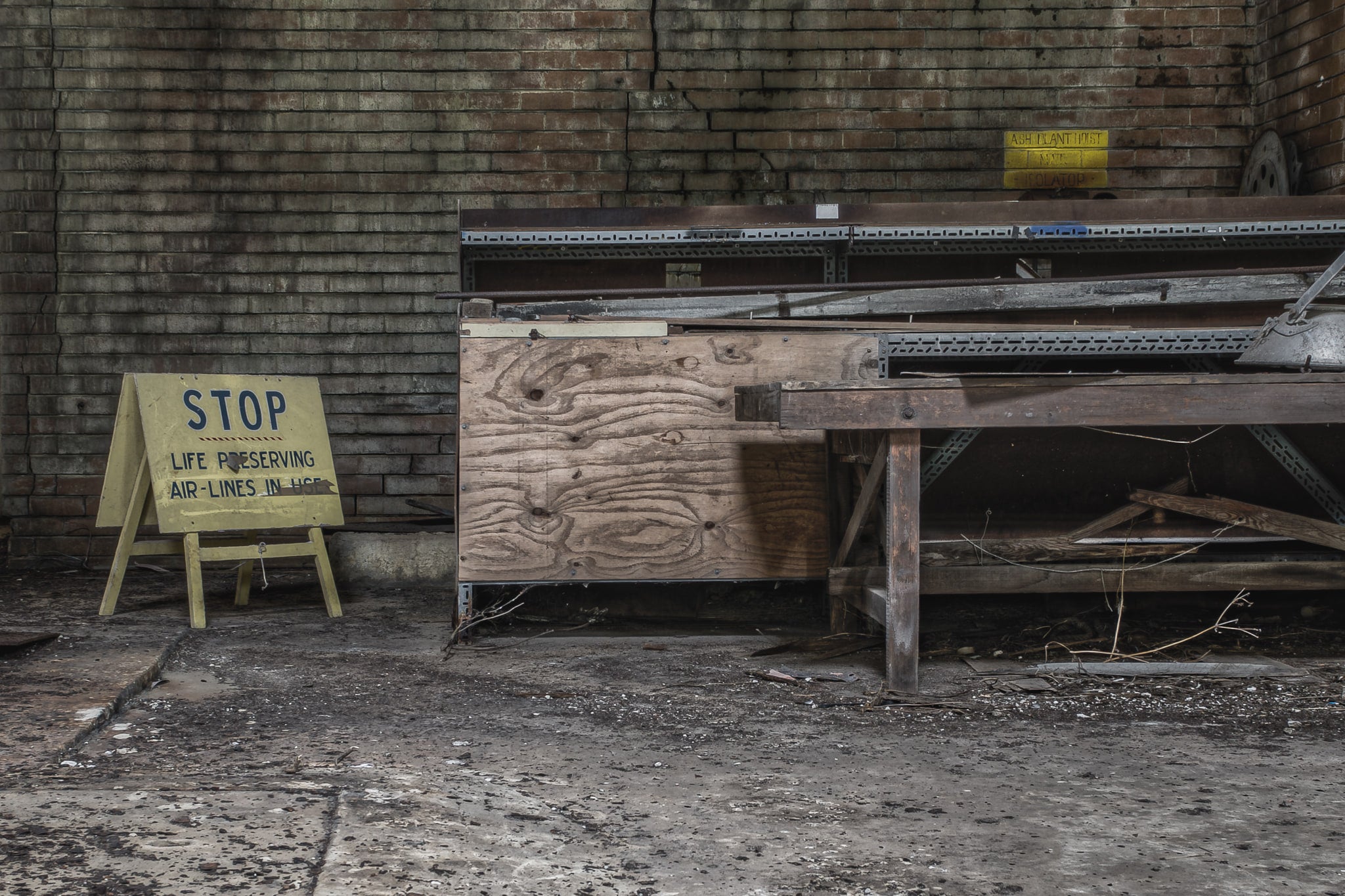 Ash Plant Workshop at Wangi Power Station, a yellow A-frame safety sign sits on the concrete floor.