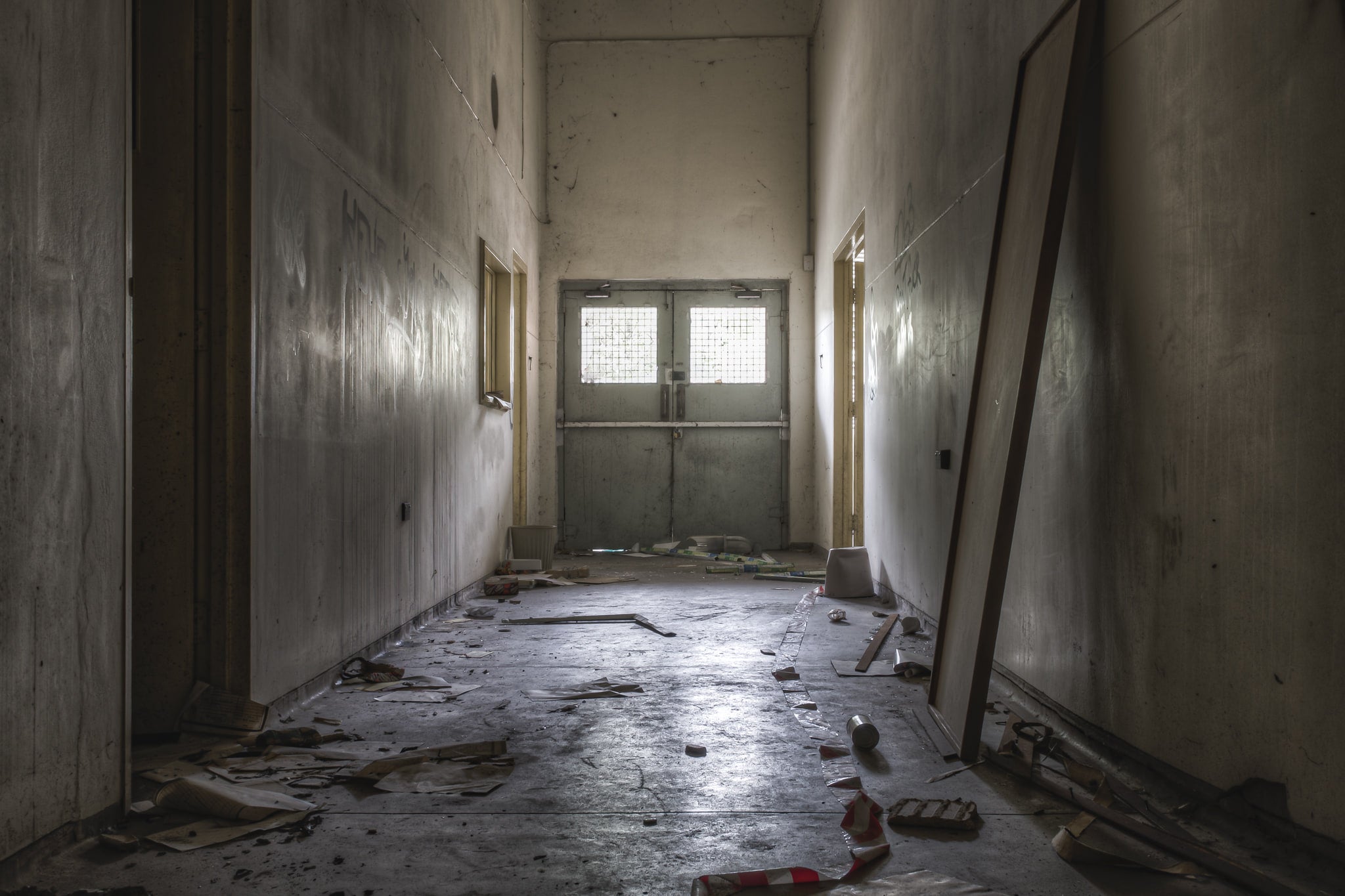 Hallway at Wangi Power Station, a narrow corridor runs toward a pair of steel double doors.