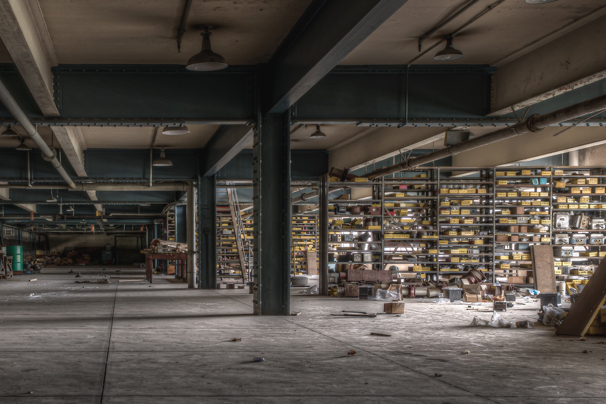 Store Roof 2 at Wangi Power Station, steel columns painted dark teal carry heavy I-beams across a low ceiling.