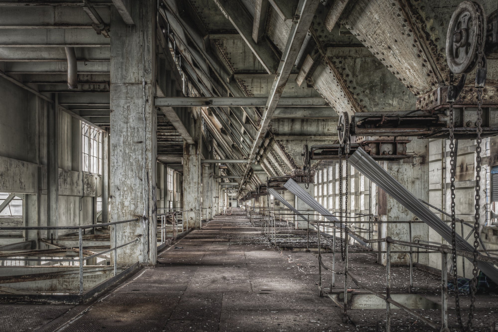 Weigher Floor at Wangi Power Station, a long concrete corridor stretches deep into the building, flanked by steel railings.
