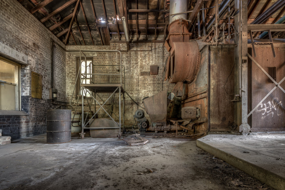 Boiler House at Waterfall Sanatorium, a heavy industrial boiler sits against the far wall, its casing oxidised to a deep.