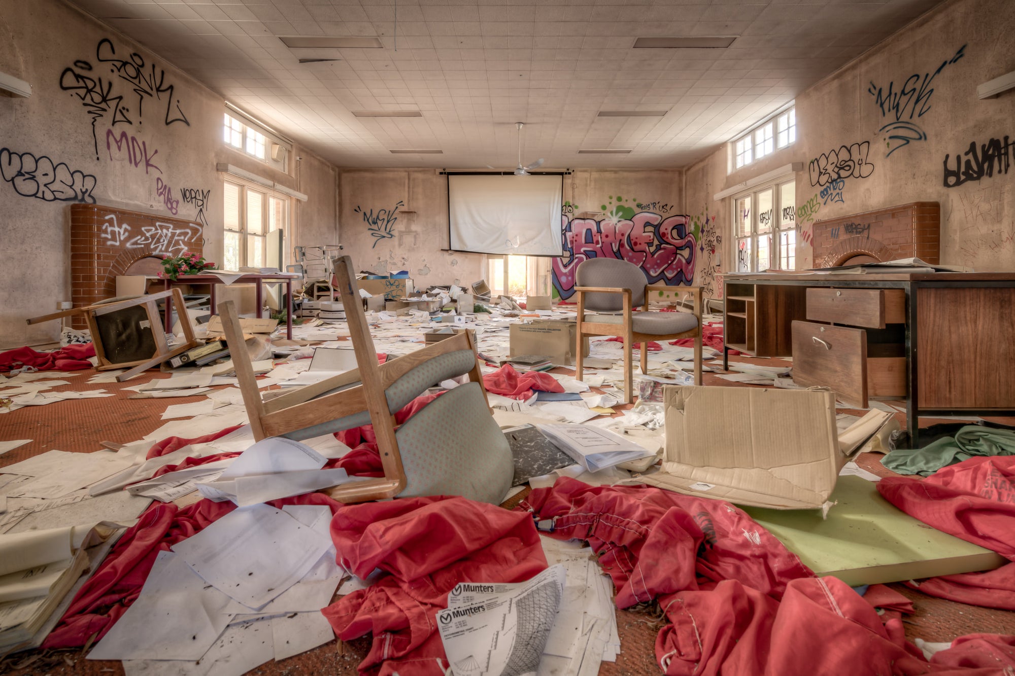 The Document Room at Waterfall Sanatorium, patient documents, strewn across a heavily graffitied room with upturned.