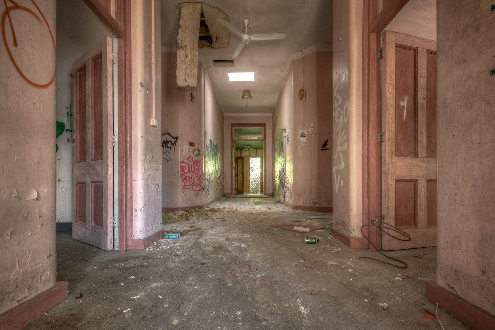 Every Which Way at Waterfall Sanatorium, a corridor runs deep into the building, its pink-painted walls faded to a chalky.