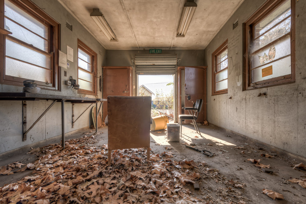 Fallen at Waterfall Sanatorium, dead leaves surrounding a chair in a small utility room.