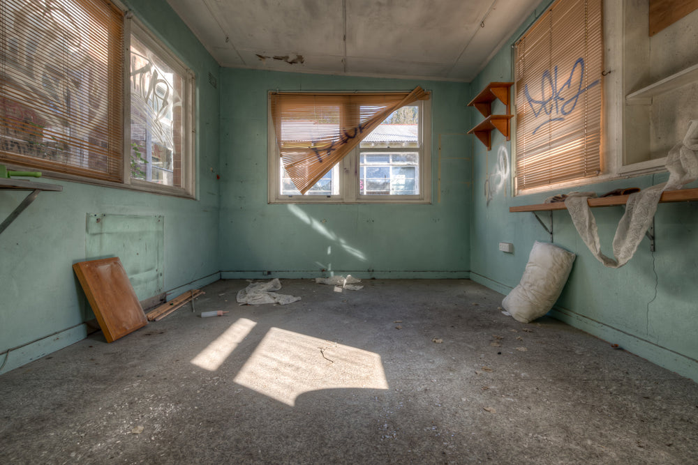 Peeking Through The Blinds at Waterfall Sanatorium, pale green walls hold three windows.