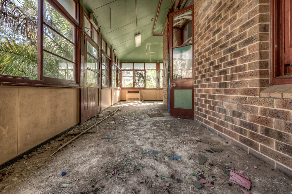 Rainforest Escape at Waterfall Sanatorium, a covered verandah runs along the brick facade of a ward building.