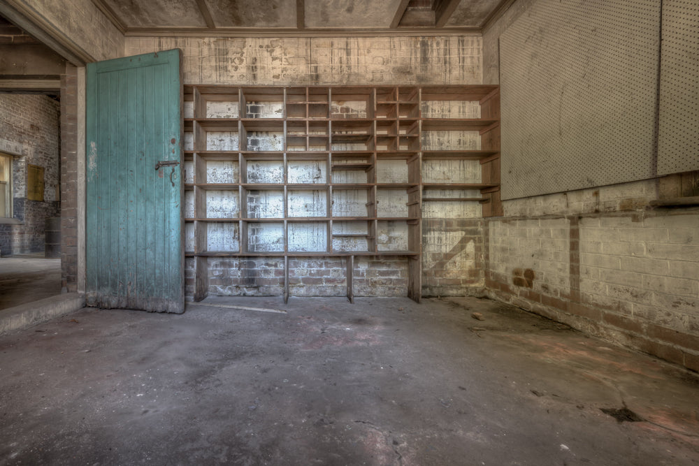 Storage Shelves at Waterfall Sanatorium, a timber shelving unit covers the back wall, its grid of open compartments.