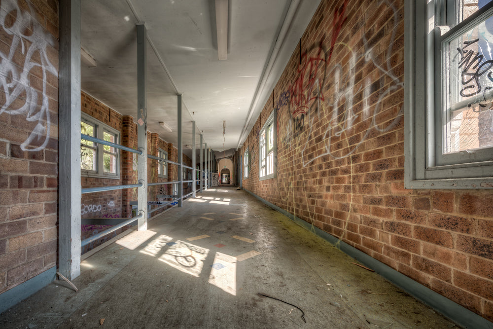 Switchback at Waterfall Sanatorium, a long corridor stretches deep into the building, flanked by brown brick walls thick.