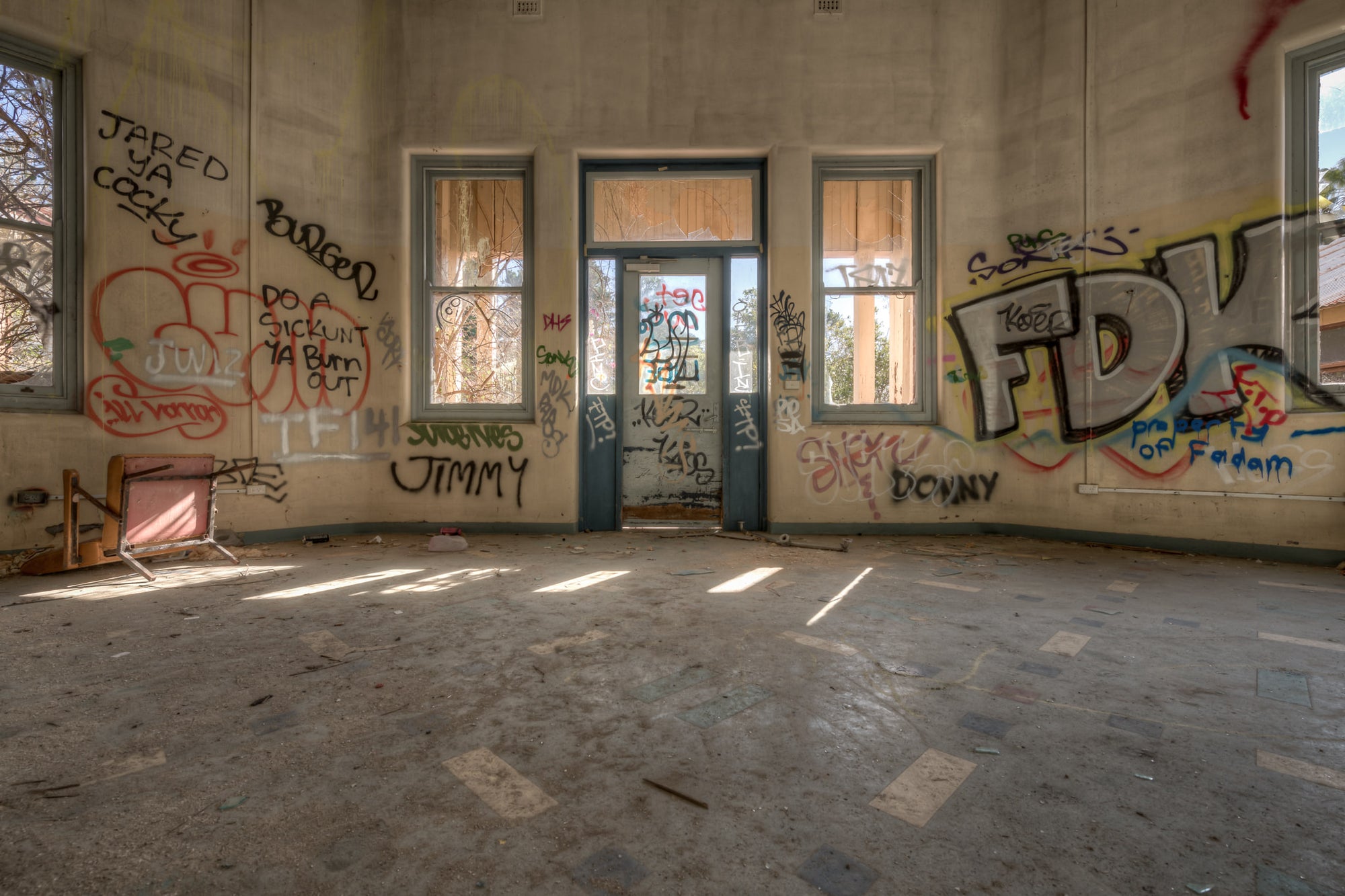 The Way Out at Waterfall Sanatorium, sunlight falls in pale strips across a bare concrete floor.