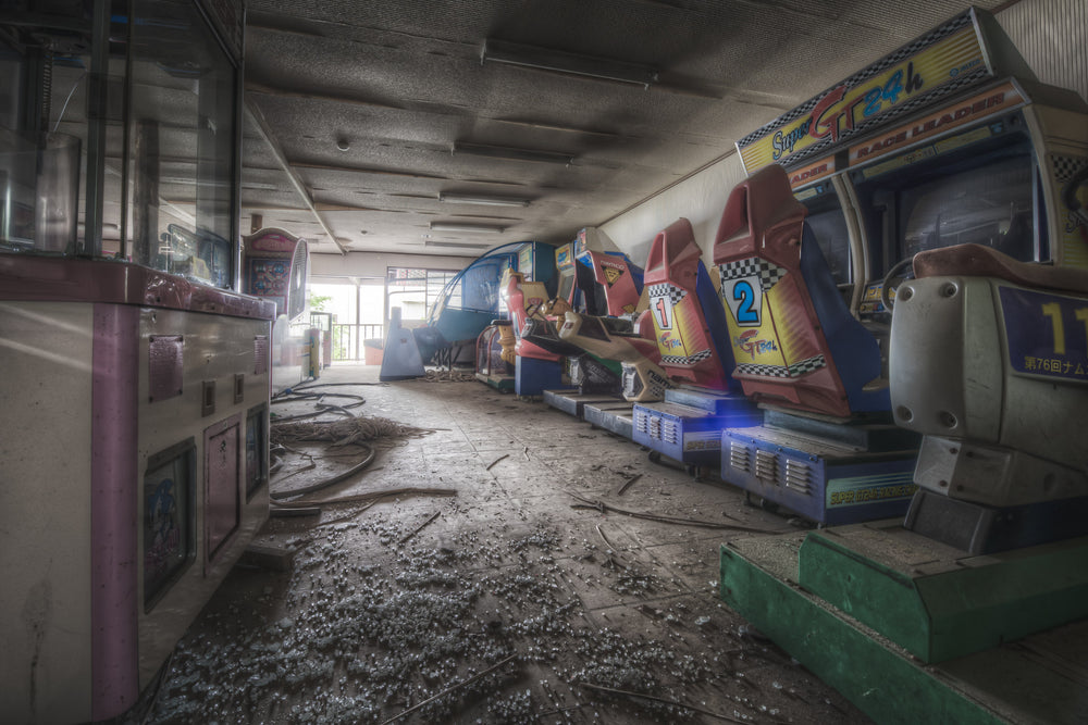 Arcade at Western Village, rows of multiplayer arcade machines left behind amongst a floor covered in shattered glass.