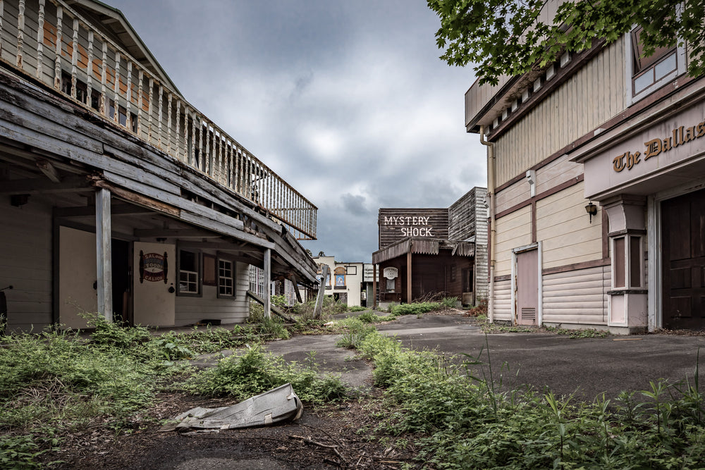 Downtown at Western Village, weeds push through the walkway between rows of wild western themed buildings.