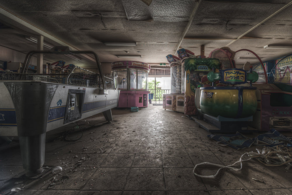 Games at Western Village, coin-operated amusement rides line both sides of a low-ceilinged arcade hall.