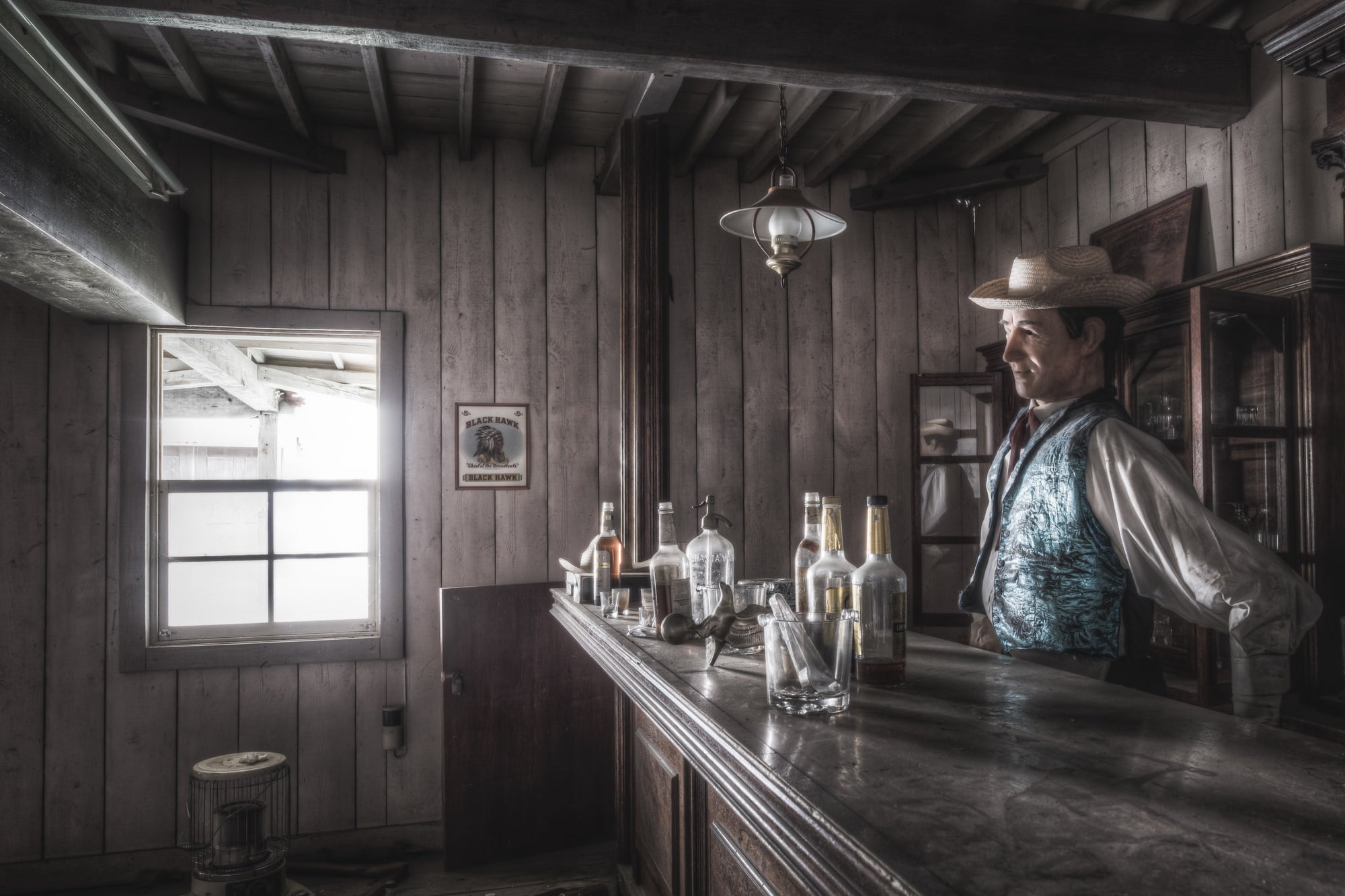 Saloon at Western Village, the bartender of the Western Village saloon stands behind the dimly lit bar.