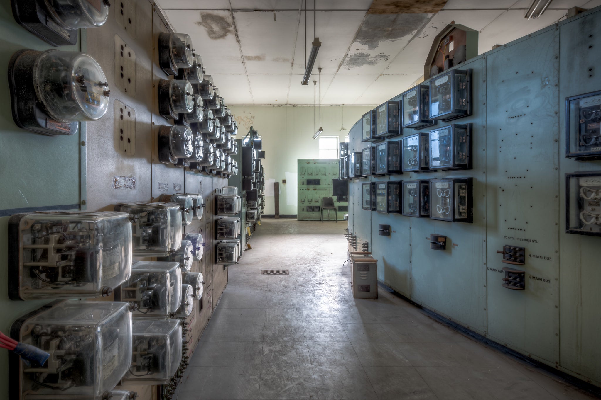 Ammeter Wall at White Bay Power Station, rows of glass-cased ammeters and relay instruments line both walls of a narrow.