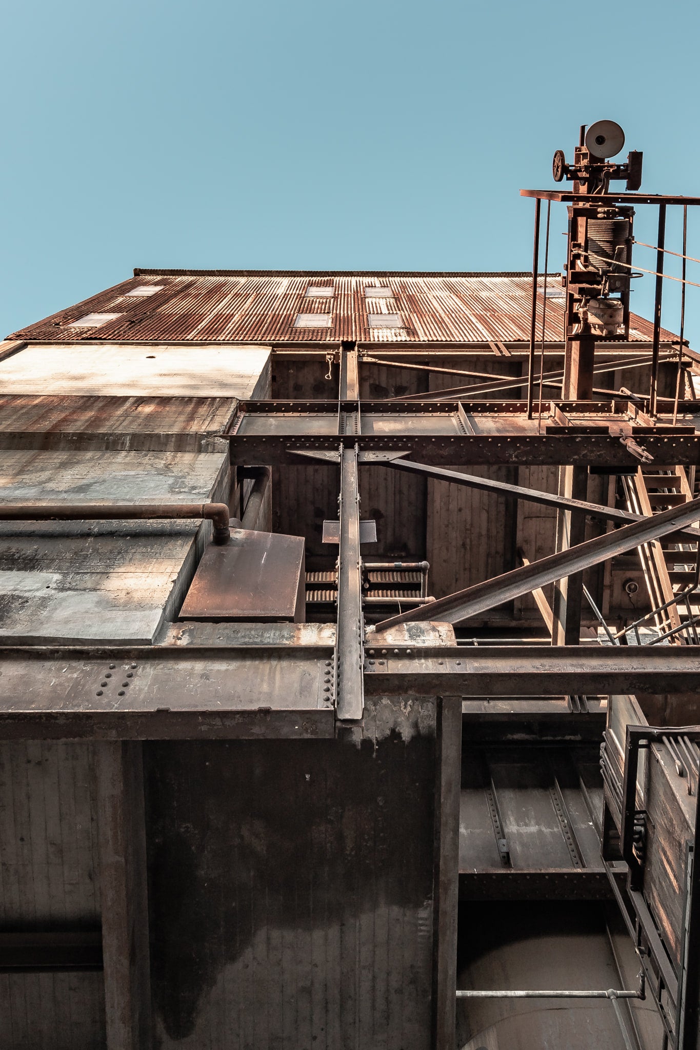 Ash Handling Tower Lookup at White Bay Power Station, steel beams and concrete walls stack upward in heavy layers.