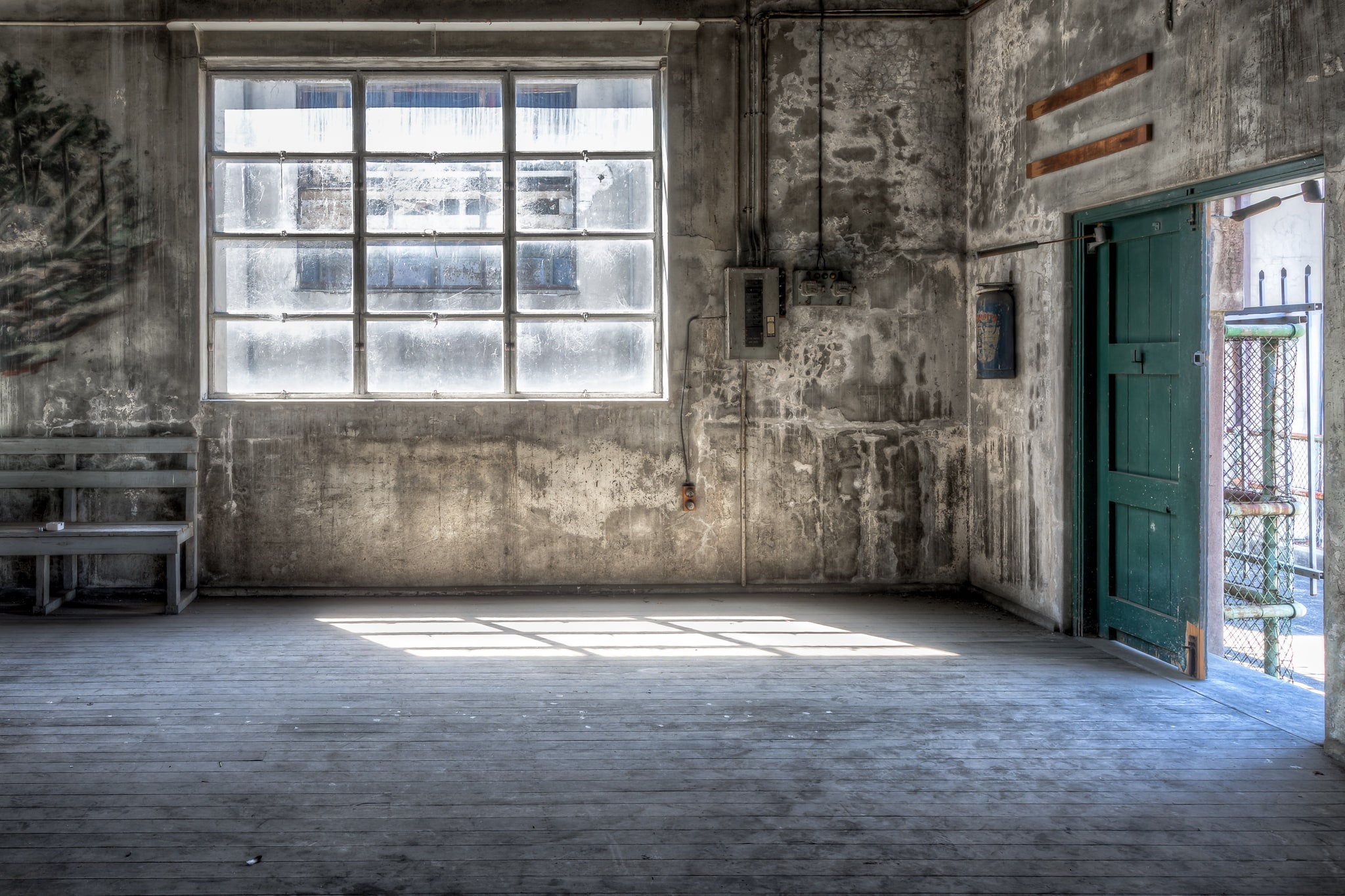 Entertainment Hall Door at White Bay Power Station, light spills through the open doorway, cutting across the worn timber.