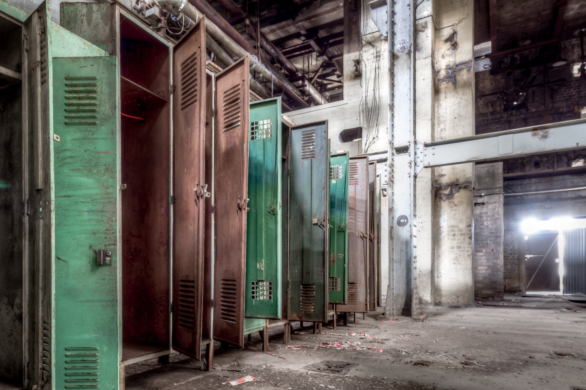 Lockers at White Bay Power Station, steel lockers line a concrete wall, doors hanging open.
