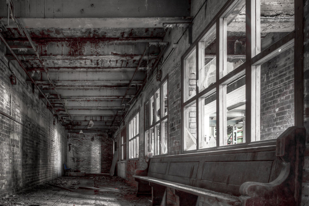 Lunch Room at White Bay Power Station, a timber church pew sits against a wall of broken windows in a narrow brick corridor.