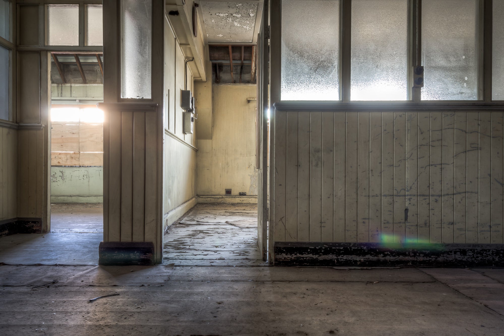 Offices at White Bay Power Station, frosted glass panels line the partition wall, their surface clouded with grime.