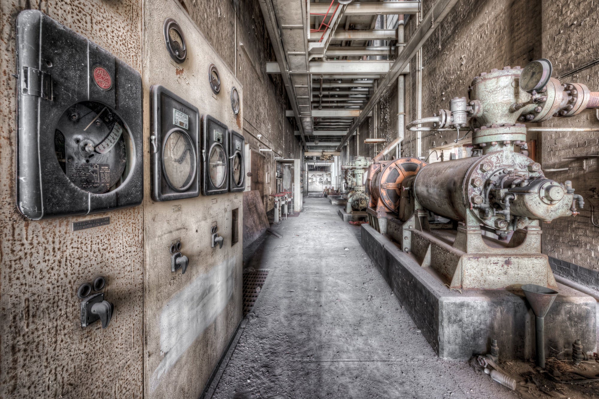 Pump House Equipment at White Bay Power Station, a narrow service corridor runs between a row of heavy cast-iron pumps.