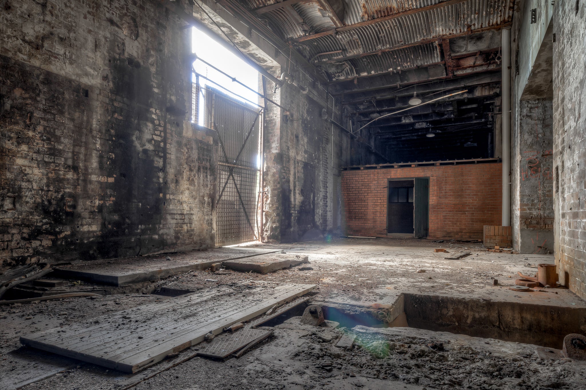 Rail Corridor Exit at White Bay Power Station, light enters through a high industrial opening on the left wall, falling.