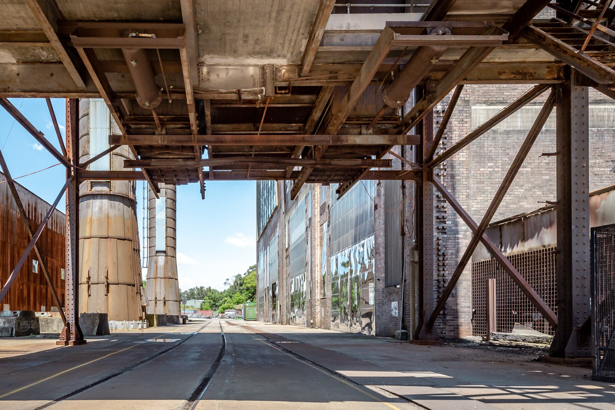 Railway Corridor at White Bay Power Station, rail lines run flush with the concrete floor beneath a heavy steel gantry.