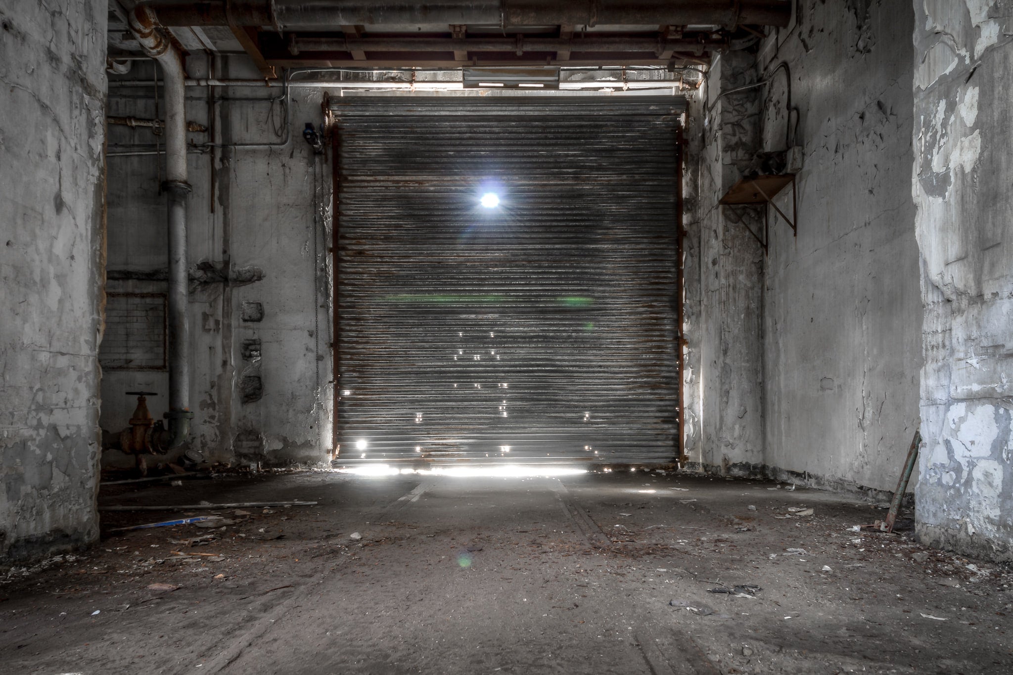 Roller Door at White Bay Power Station, a steel roller door fills the frame, sealed shut between concrete walls.