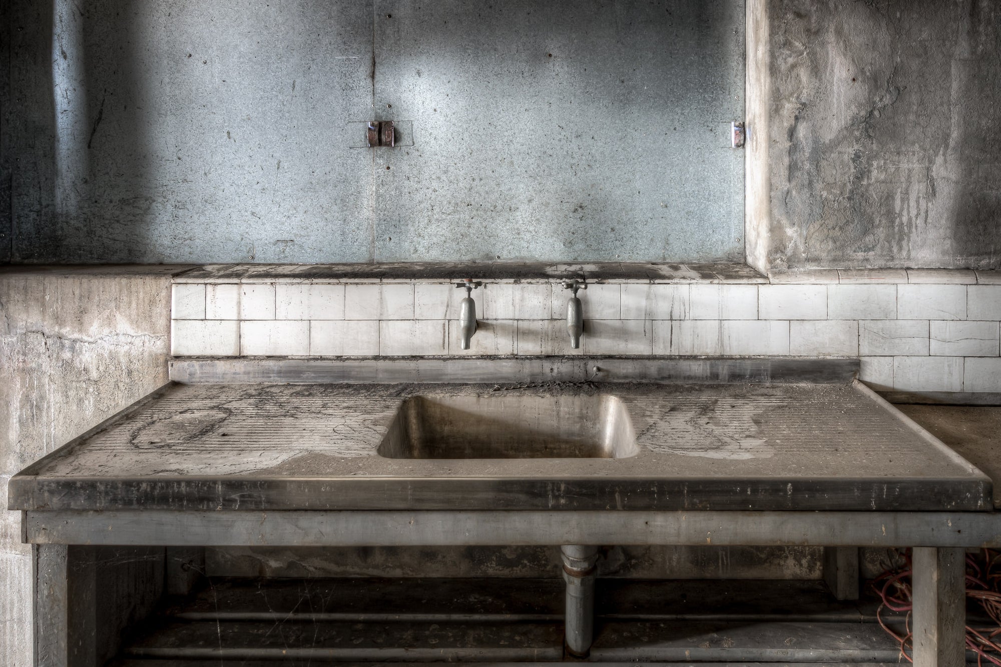 Sink at White Bay Power Station, a stainless steel sink sits square in the frame, its draining boards thick with grey dust.