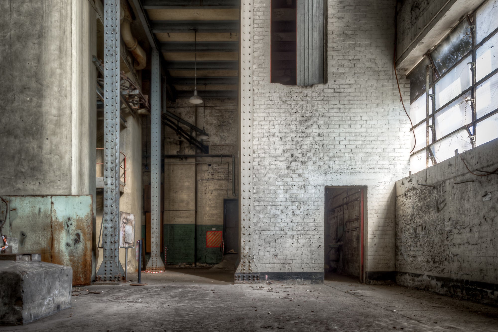 Turbine Hall Basement North End at White Bay Power Station, white-painted brick rises two storeys to meet riveted steel.