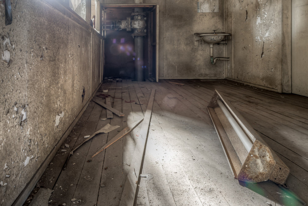 Turbine Hall Crib Room at White Bay Power Station, a fluorescent light fixture lies face-down on bare timber floorboards.