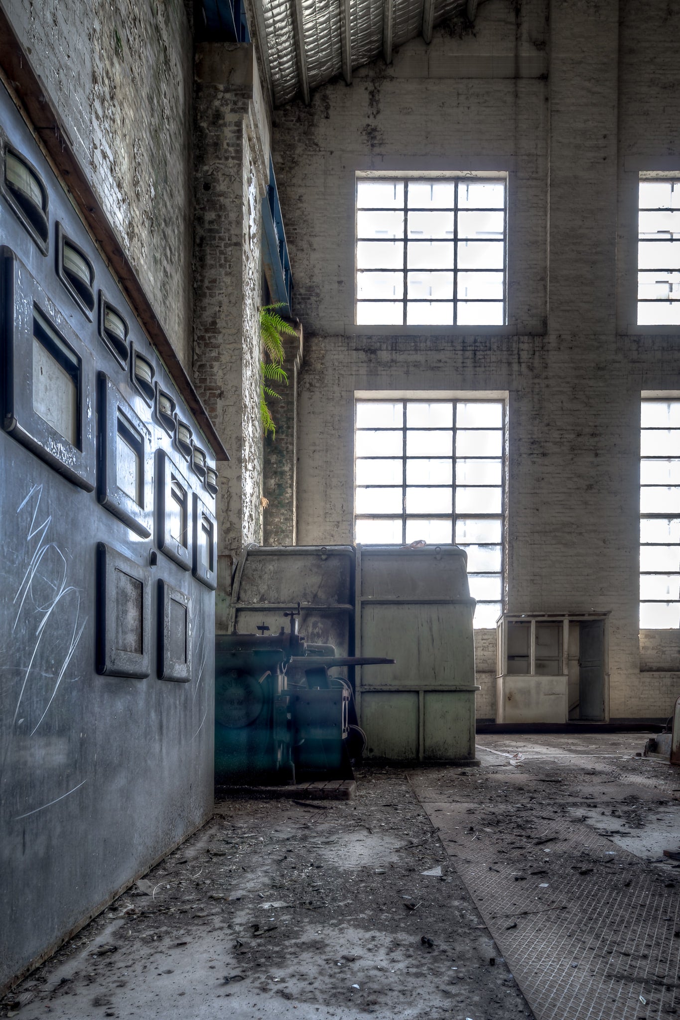 Turbine Hall Windows at White Bay Power Station, a steel indicator panel lines the left wall, its gauge windows dark.