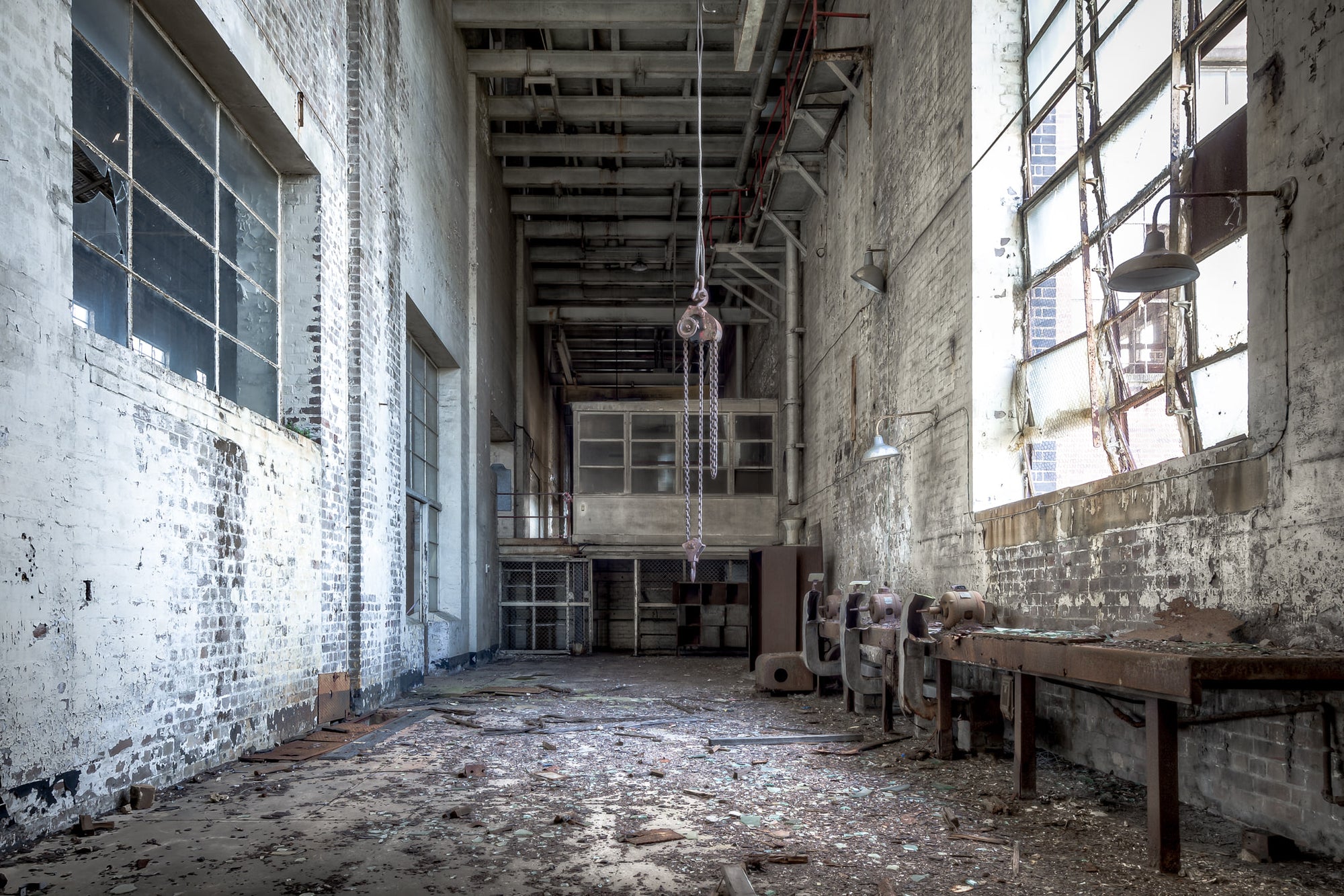 Workshop at White Bay Power Station, a chain block hangs from the ceiling on heavy links, motionless above a floor thick.