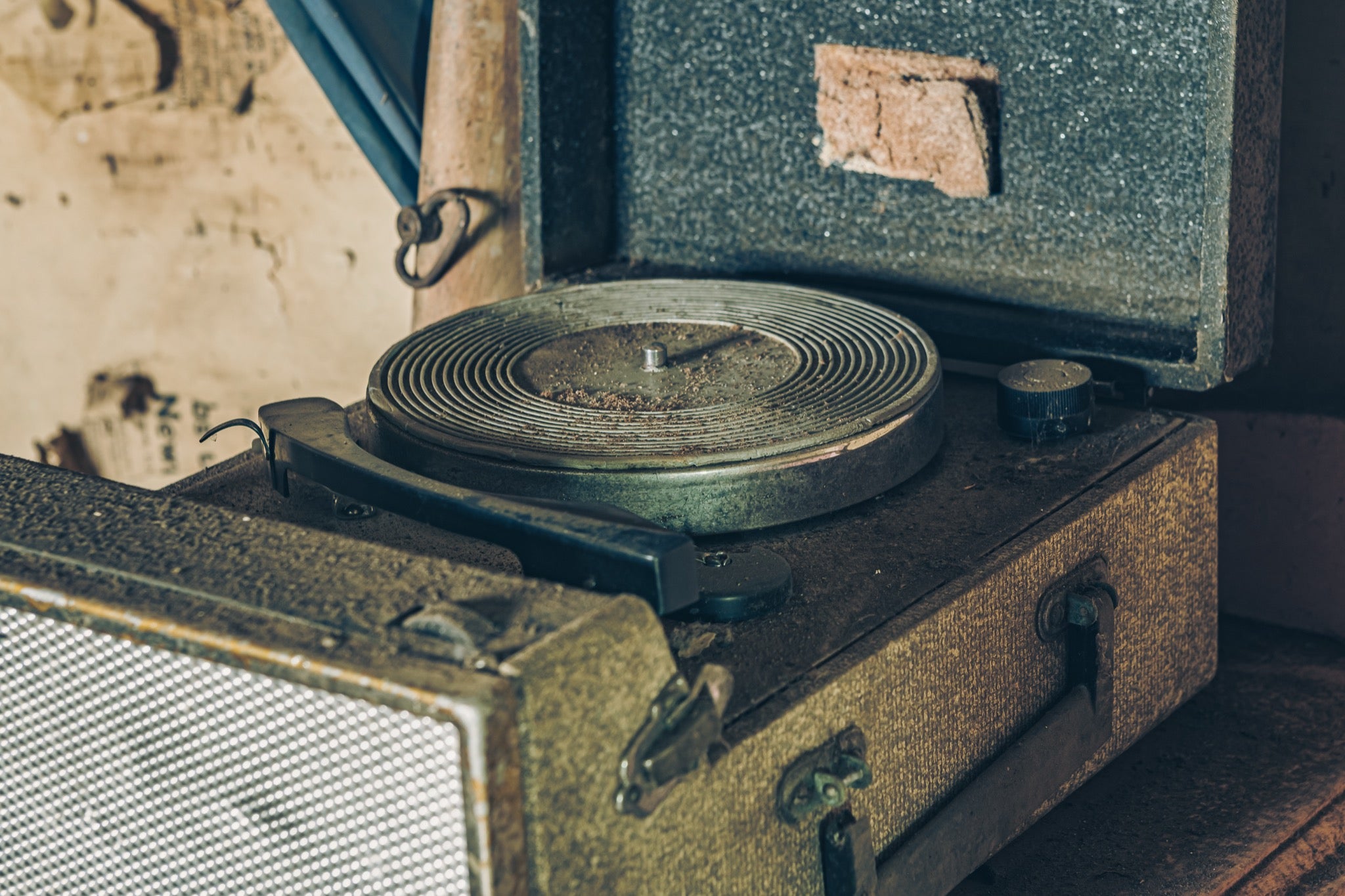 An open portable record player with a dusty ribbed metal turntable and worn fabric case, photographed in the Deua River Valley.