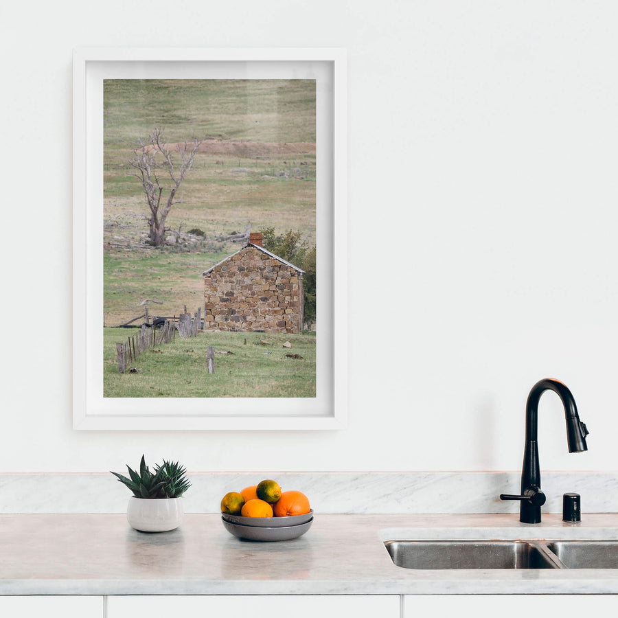 Jindabyne Hut at A Place to Call Home, a stone cottage sits low in open pastoral land near Jindabyne.