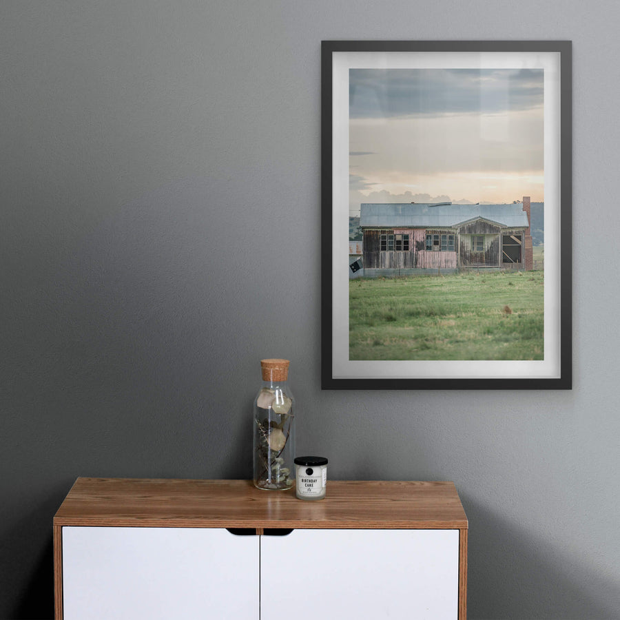 Matong Hut at A Place to Call Home, a weatherboard farmhouse sits low in open green paddock.