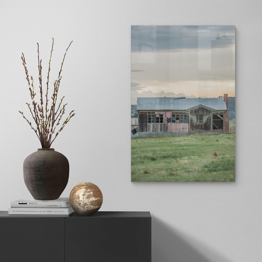 Matong Hut at A Place to Call Home, a weatherboard farmhouse sits low in open green paddock.